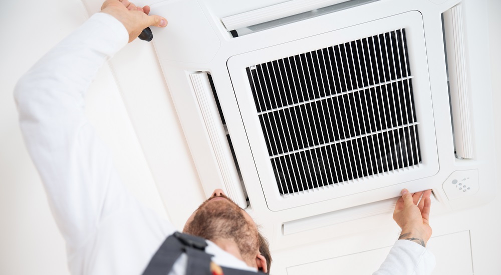 Klimaanlagenmonteur montiert eine neue Klimaanlage beim Kunden